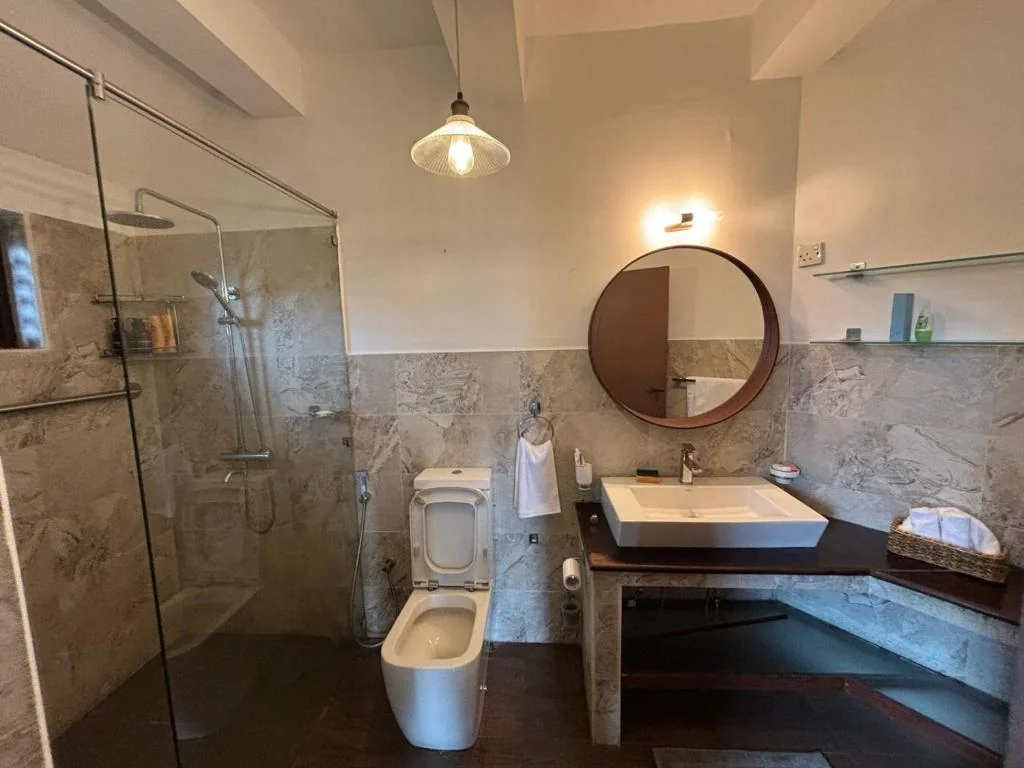 Master Bathroom with Circular Mirror & Glass Shower